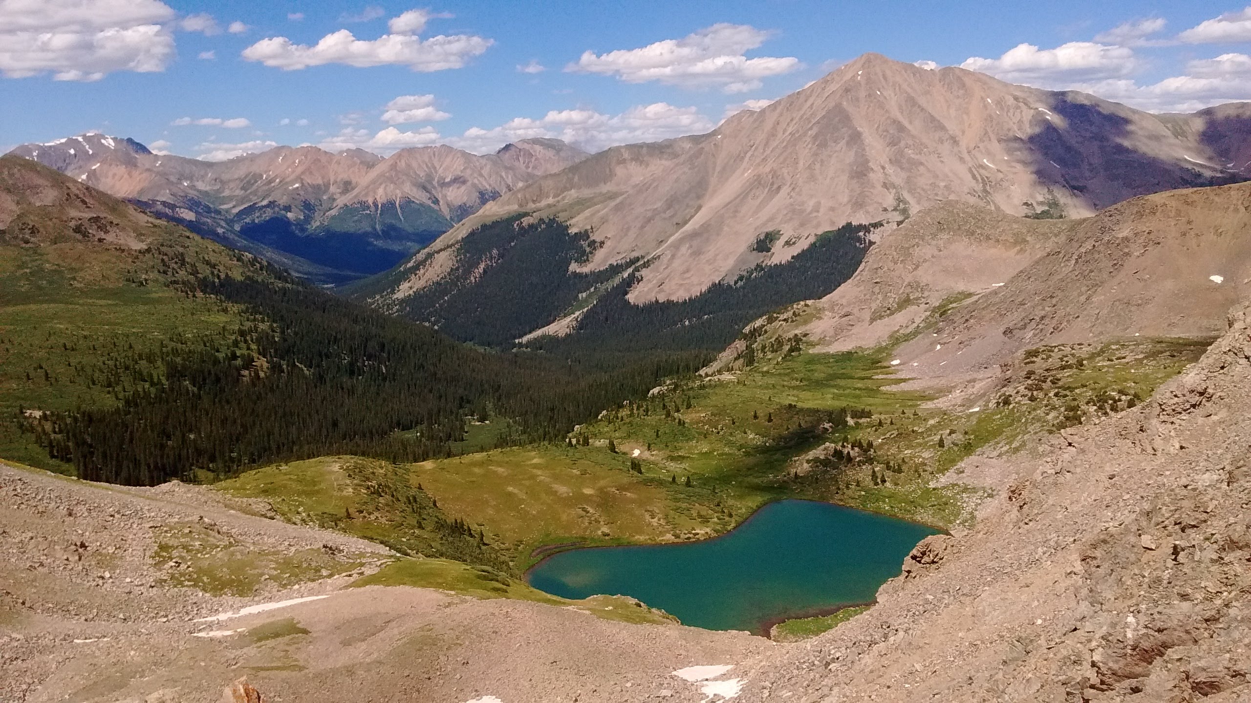 A view looking down towards an alpine lake from high in the mountains