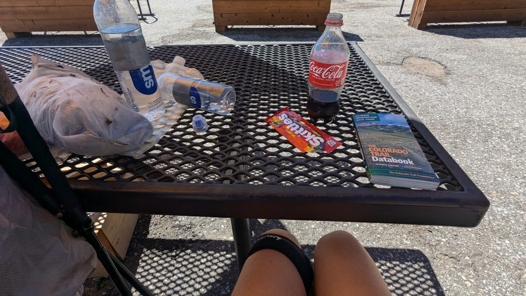 A picnic table with candy and soda on it