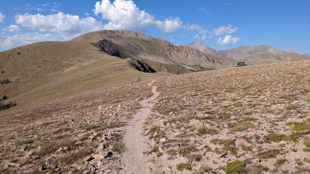 A trail going up a large tree-less mountain