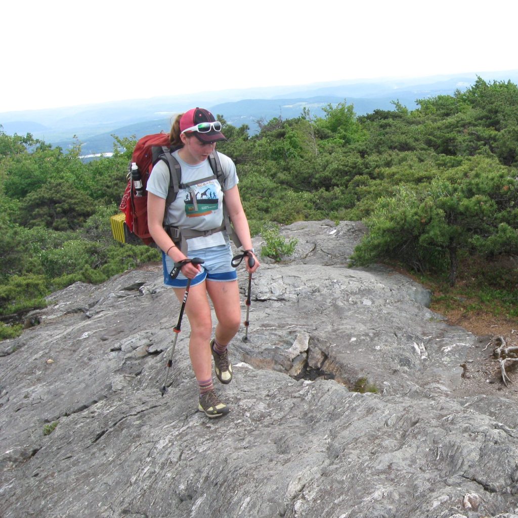 Backpacker walking across some rocks