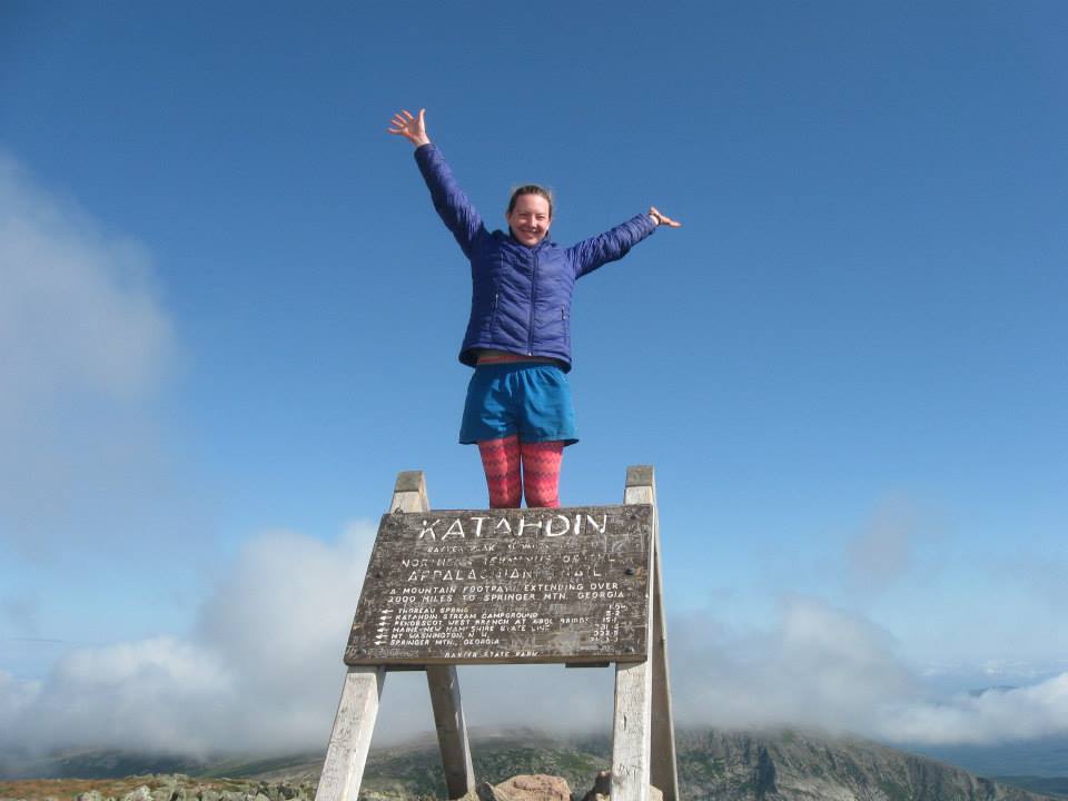 woman standing on a sign that says "Katahdin"