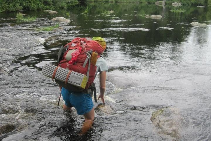 A woman standing in a knee-deep river