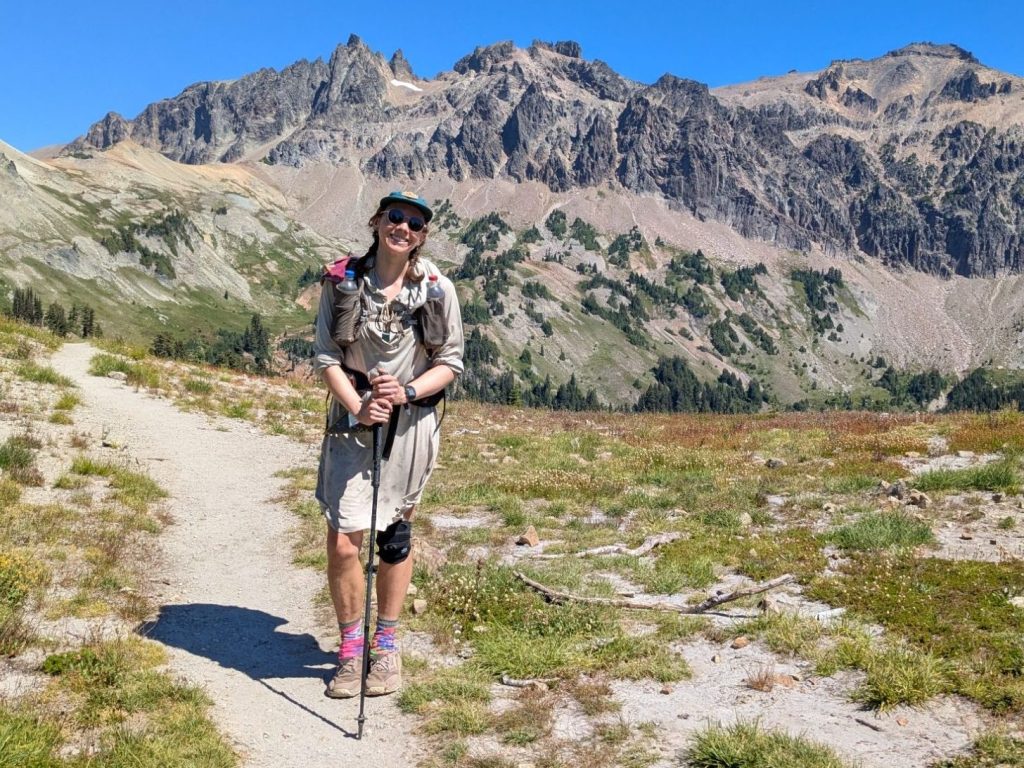 backpacker in a dress with one trekking pole